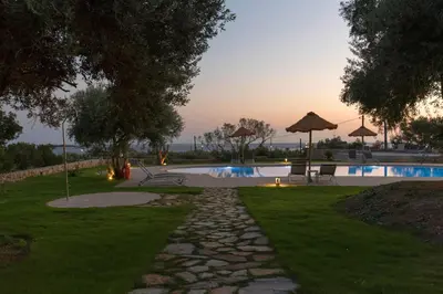 a backyard with a swimming pool with trees and grass at Libyan Mare in Palaiochóra