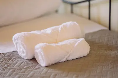 a white towel laying on top of a bed at Nicola's House in Tsivarás