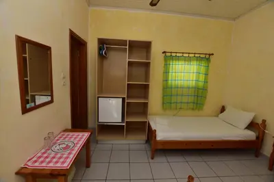 a small room with a bed and a tv at Anonymous Homestay in Palaiochóra