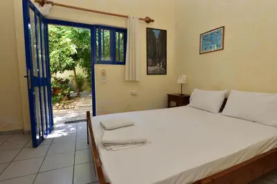 a bedroom with a large bed and a sliding glass door at Anonymous Homestay in Palaiochóra
