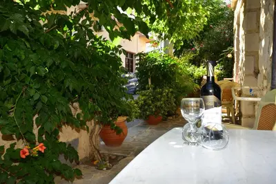 a bottle of wine and two wine glasses on a table at Anonymous Homestay in Palaiochóra