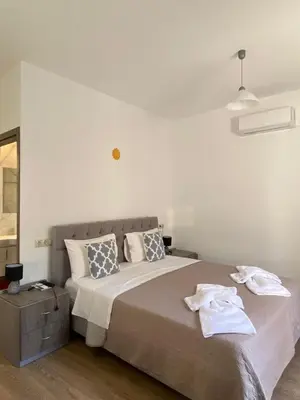 a bedroom with a large bed with towels on it at Tile Apartments 4 in Agia Marina Nea Kydonias