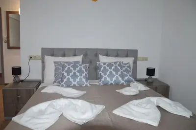 a bed with white sheets and pillows on it at Tile Apartments 4 in Agia Marina Nea Kydonias
