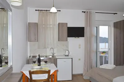 a kitchen with a table and a sink and a room at Tile Apartments 5 in Agia Marina Nea Kydonias