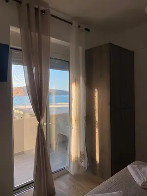 a bedroom with a large window with a view of the ocean at Tile Apartments 5 in Agia Marina Nea Kydonias