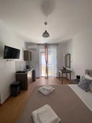 a living room with a bed and a tv at Tile Apartments 6 in Agia Marina Nea Kydonias