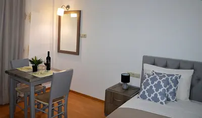 a bedroom with a bed and a table and a mirror at Tile Apartments 6 in Agia Marina Nea Kydonias