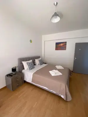 a bedroom with a bed in a room with a lamp at Tile Apartments 6 in Agia Marina Nea Kydonias
