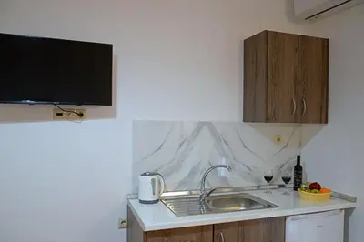 a kitchen with a sink and a tv on the wall at Tile Apartments 6 in Agia Marina Nea Kydonias