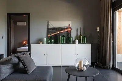 a living room with a couch and a table with wine bottles at Calmar Boutique Villa 5min drive to Kolymvari beach with Private Pool & Sea Views in Kolymvari