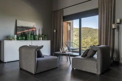 a living room with two chairs and a window at Calmar Boutique Villa 5min drive to Kolymvari beach with Private Pool & Sea Views in Kolymvari