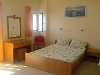 a bedroom with a bed and a desk and a mirror at Seaview Studio in beautiful setting, west from Chania in Ravdhoúkha