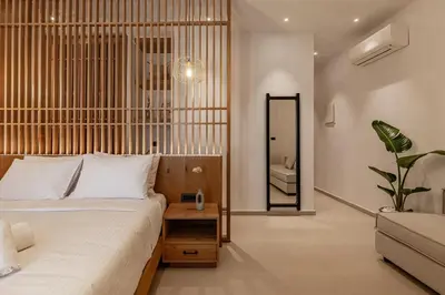 a bedroom with a large bed and a mirror at Sarana Suites Crete in Kissamos