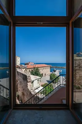 a large window with a view of the ocean at Pallazzo Dei Miracoli - Luxe 3BR apt Sea & Old Port Terrace View in Chania Town