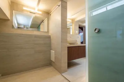 a bathroom with a sink and a glass door at Pallazzo Dei Miracoli - Luxe 3BR apt Sea & Old Port Terrace View in Chania Town