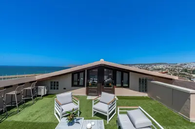 a house with a patio and chairs on the roof at Pallazzo Dei Miracoli - Luxe 3BR apt Sea & Old Port Terrace View in Chania Town