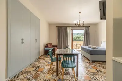 a room with a bed and a table and chairs at Altirina Studios in Almirida