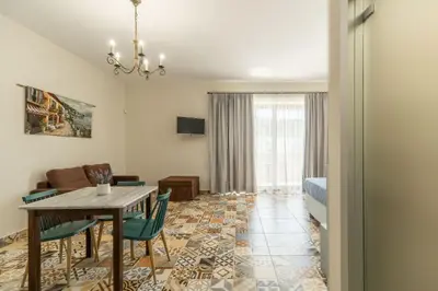 a living room with a table and chairs and a couch at Altirina Studios in Almirida