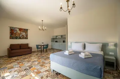a bedroom with a bed and a couch and a table at Altirina Studios in Almirida