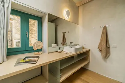 a bathroom with a sink and a mirror at Panaretos Deluxe Maisonette in Chania Town