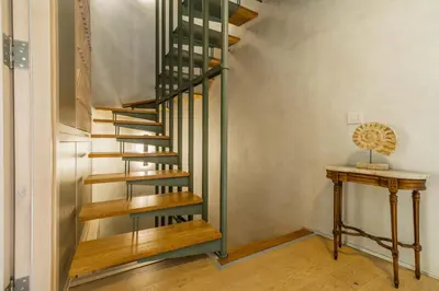a wooden spiral staircase in a room with a table at Panaretos Deluxe Maisonette in Chania Town