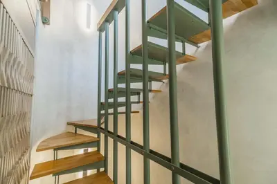 a spiral staircase in a house with green railings at Panaretos Deluxe Maisonette in Chania Town