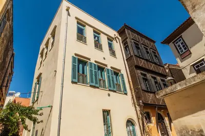 a building with green shuttered windows on a street at Panaretos Deluxe Maisonette in Chania Town