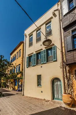 a building with green shuttered windows on a street at Panaretos Deluxe Maisonette in Chania Town