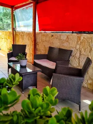 a patio with a couch and chairs and a table at La Casa di Teta by superhosthub in Galatás
