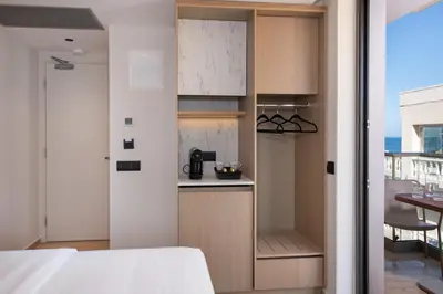 a room with a kitchen with a bed and a table at EdgeWater Beach Hotel in Chania Town