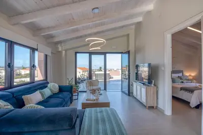 a living room with a blue couch and a bed at Angela Home, 5Street, Perivolia in Perivólia
