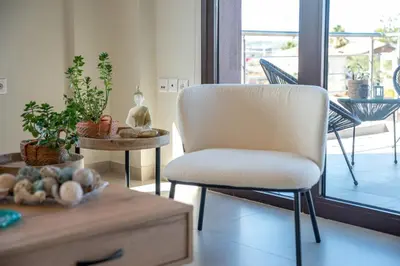 a chair sitting in a living room with a table at Angela Home, 5Street, Perivolia in Perivólia