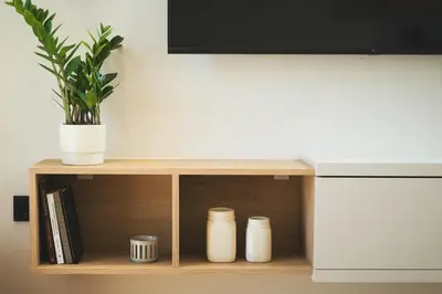 a shelf with three white vases and a television at Kydoni Signature Apartment in Chania Town