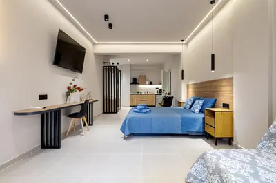 a bedroom with a blue bed and a desk at Dom Azure Studios in Agia Marina Nea Kydonias