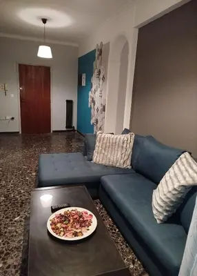 a living room with a blue couch and a plate on a table at Serenity Apartment Chania City Centre in Chania Town