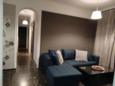 a living room with a blue couch and a table at Serenity Apartment Chania City Centre in Chania Town