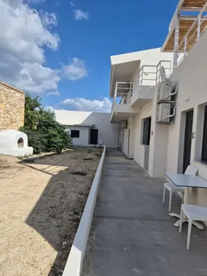 a walkway outside of a building with a table at Aldea Apartments in Módhion