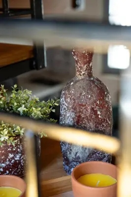 a glass bottle sitting on a table next to a plant at Amy's Little Gem in Chania Town