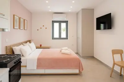 a bedroom with a bed and a kitchen with a stove at Yalos Standard Studio - 5 mins to Elafonisi beach in Agios Padeleimon