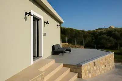 a chair sitting on a patio next to a building at Yalos Standard Studio - 5 mins to Elafonisi beach in Agios Padeleimon