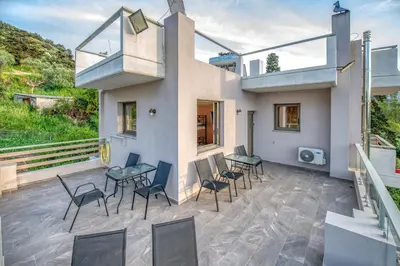 a patio with chairs and tables and a balcony at Earthly Paradise in Kissamos