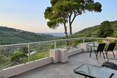 a balcony with chairs and a view of the ocean at Earthly Paradise in Kissamos