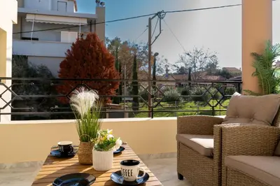 a patio with a table and chairs and a balcony at Nafsika's Cozy Apartment in Chania Town