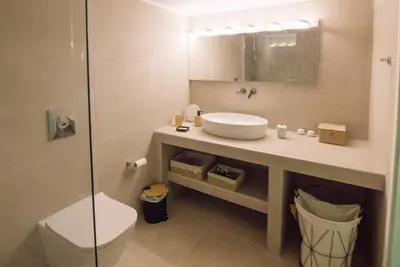 a bathroom with a sink and a toilet and a shower at ARETOUSA Seafront House in Kalyves
