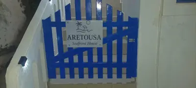 a blue gate with a sign on it in a hallway at ARETOUSA Seafront House in Kalyves