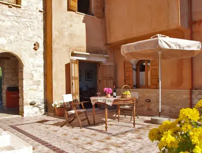 a patio with a table and an umbrella at Natalia's Houses in Chania Town