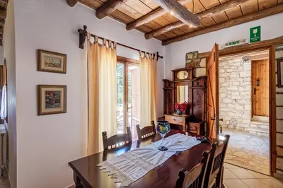 a dining room with a wooden table with chairs and a window at Natalia's Houses in Chania Town