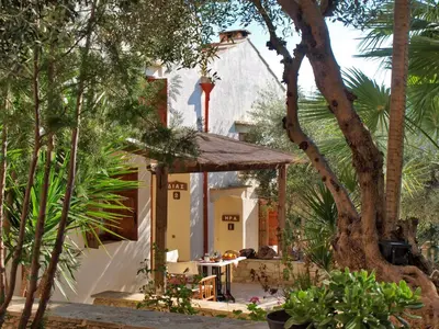 a garden with a table and a building at Natalia's Houses in Chania Town