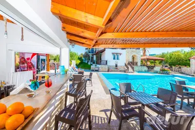 a patio with a table and chairs and a swimming pool at Ledra Maleme Hotel in Maleme