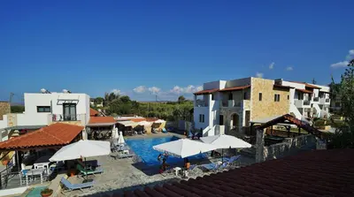 a resort with a pool with umbrellas and buildings at Ledra Maleme Hotel in Maleme